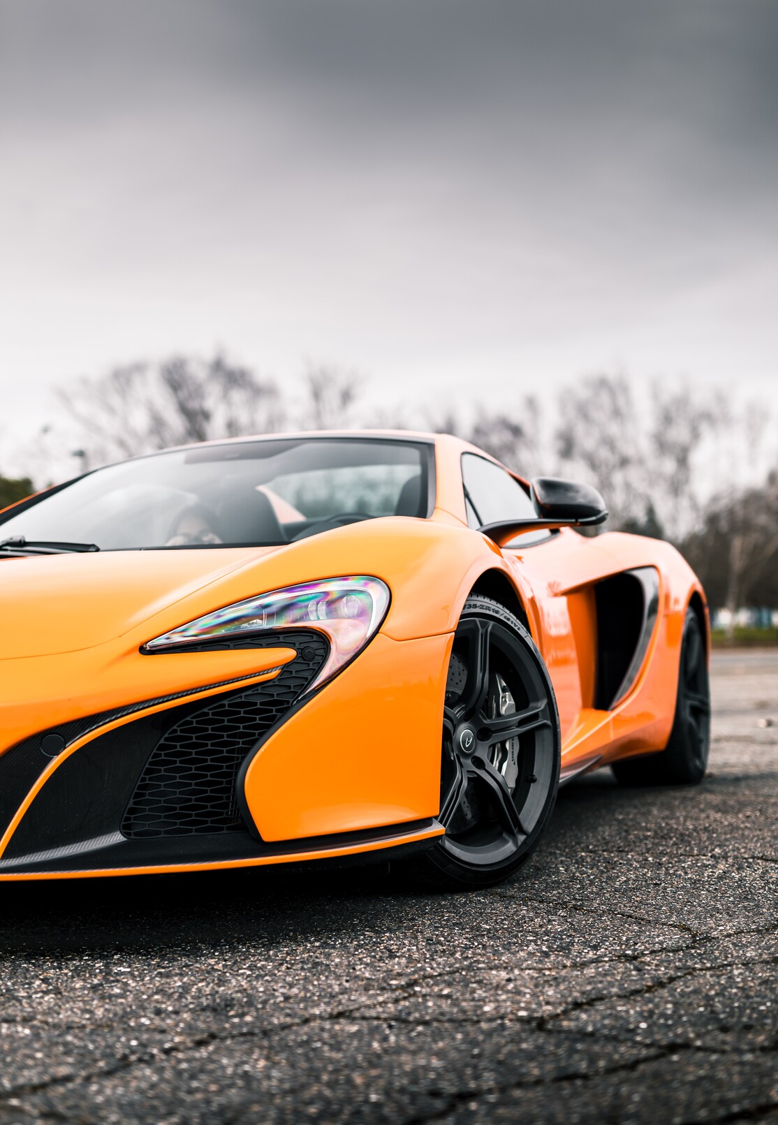 Seattle, WA, USA 1/9/2022 Orange McLaren car parked on asphalt with grey skies overhead